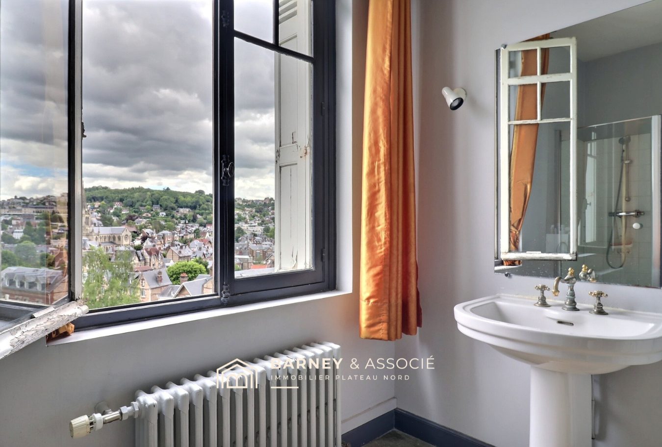 Salle de bain avec vue à Mont-Saint-Aignan Vue intérieure d'une salle de bain avec lavabo et fenêtre donnant sur le quartier de Mont-Saint-Aignan.
