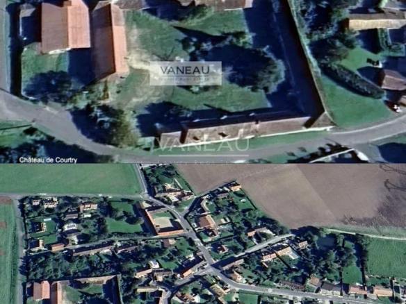 Aerial view of a walled estate with red-roof buildings inside, labeled EN 2026, with surrounding village and fields below.