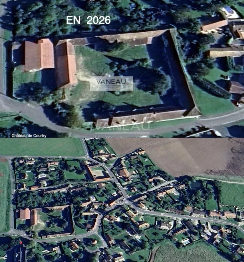 008668704715bf4333a8fea0d27c5a45_de6224e68b_918-original Aerial view of a walled estate with red-roof buildings inside, labeled EN 2026, with surrounding village and fields below.