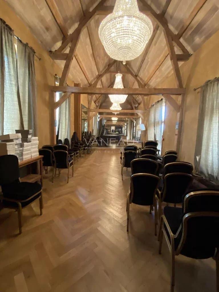 Intérieur du Manoir Henri IV avec des chaises noires et des lustres, ambiance chaleureuse.