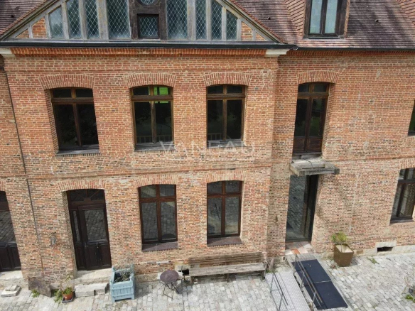 Façade du Manoir Henri IV, ancien relais de poste, avec briques apparentes et fenêtres.