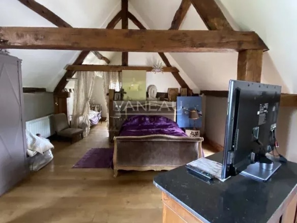 Intérieur du Manoir Henri IV avec poutres apparentes et mobilier élégant.