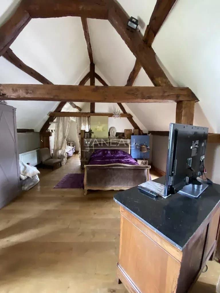 Intérieur du Manoir Henri IV avec poutres apparentes et mobilier élégant.