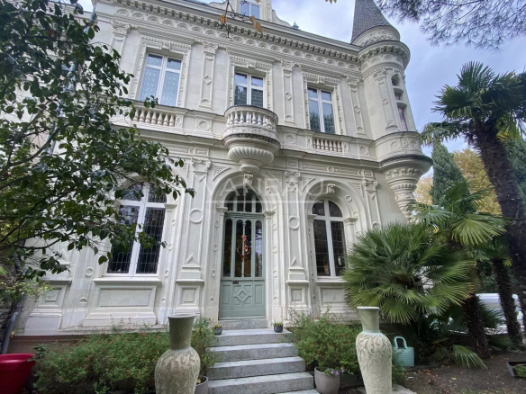 Façade d'un manoir rénové avec jardin et palmiers à Angers.