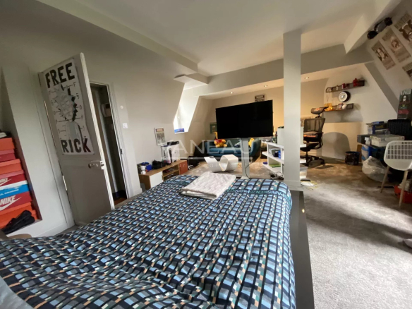 Chambre spacieuse d'un manoir rénové à Angers, avec lit, bureau et décoration moderne.