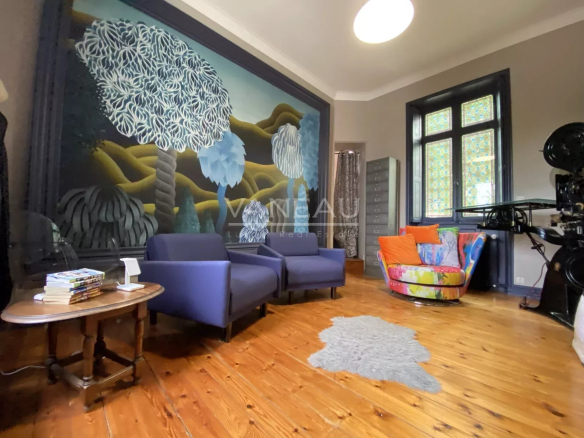 Intérieur d'un manoir rénové à Angers, avec un grand mur peint et des meubles modernes.