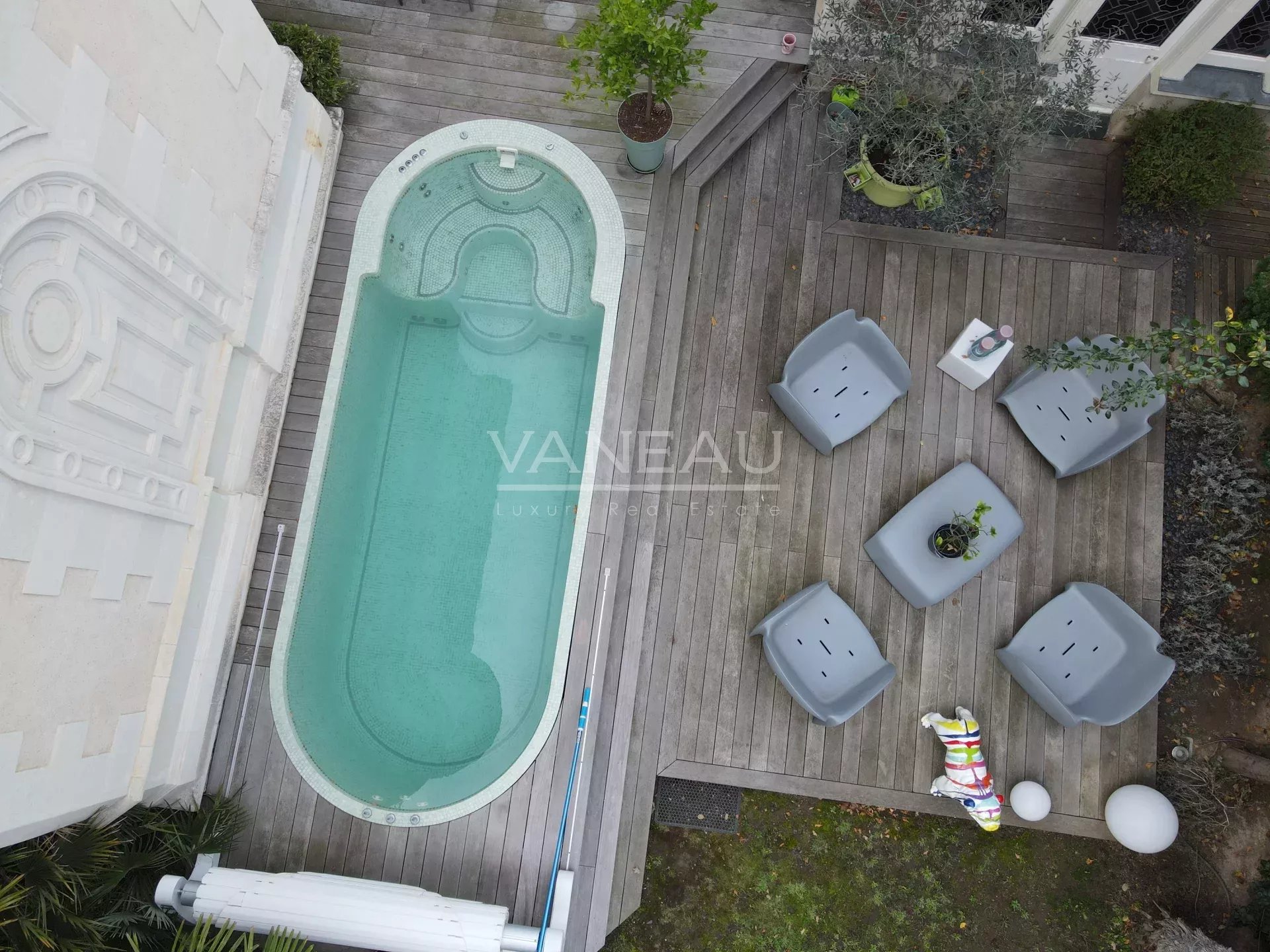 Vue aérienne d'une piscine et d'un espace détente en bois dans un manoir à Angers.