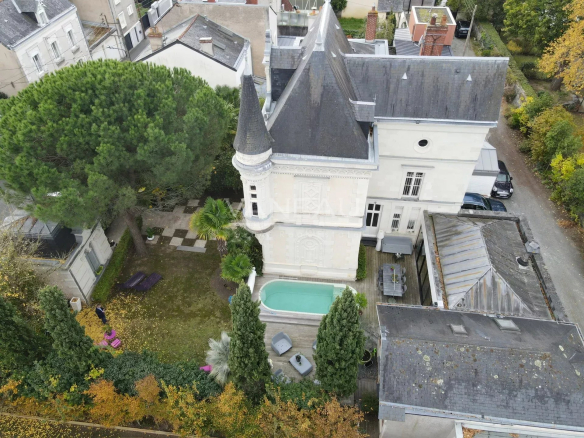 Vue aérienne d'un manoir rénové avec piscine et jardin à Angers.