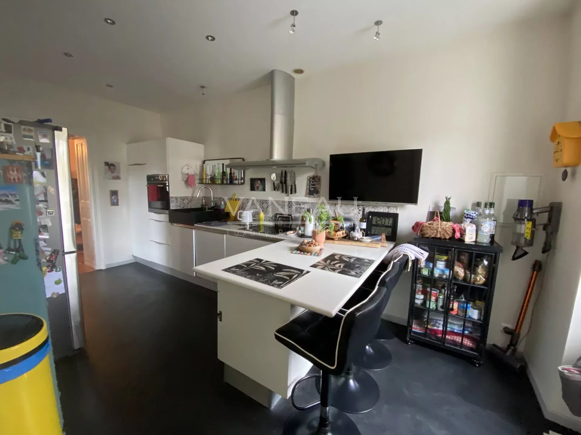 Cuisine moderne dans un manoir rénové à Angers, avec bar et équipements contemporains.