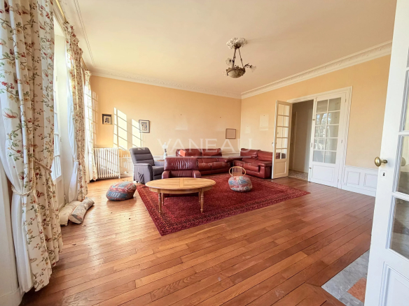 Interior of a spacious living room with sofa and rug in a farmhouse in La Chapelle-Gauthier.