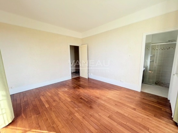 Interior of a bedroom in a historic farmhouse in La Chapelle-Gauthier, with parquet flooring and light walls.