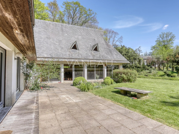 Maison d'architecte avec toitures asymétriques et jardin verdoyant à Nointot, Normandie.