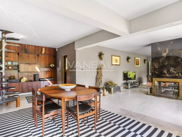 Intérieur d'une maison d'architecte moderne avec mobilier en bois et cheminée, Normandie.
