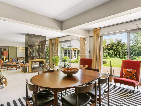 Intérieur d'une maison d'architecte moderne avec salon et salle à manger, baies vitrées et décoration contemporaine.