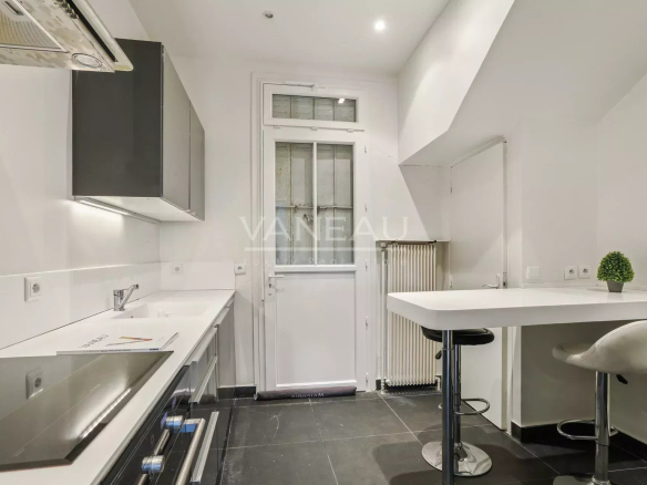 Cuisine moderne et lumineuse avec accès à l'extérieur dans une maison rénovée à Sceaux.