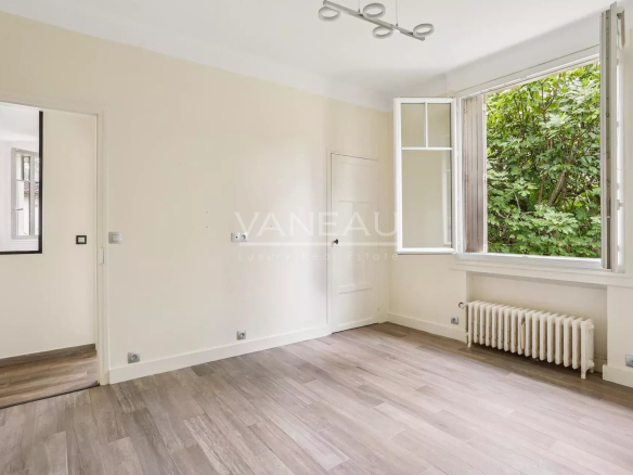 Intérieur d'une maison rénovée avec une fenêtre donnant sur un jardin verdoyant.