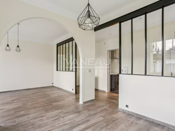 Intérieur d'une maison rénovée avec un espace ouvert et des fenêtres en verre.