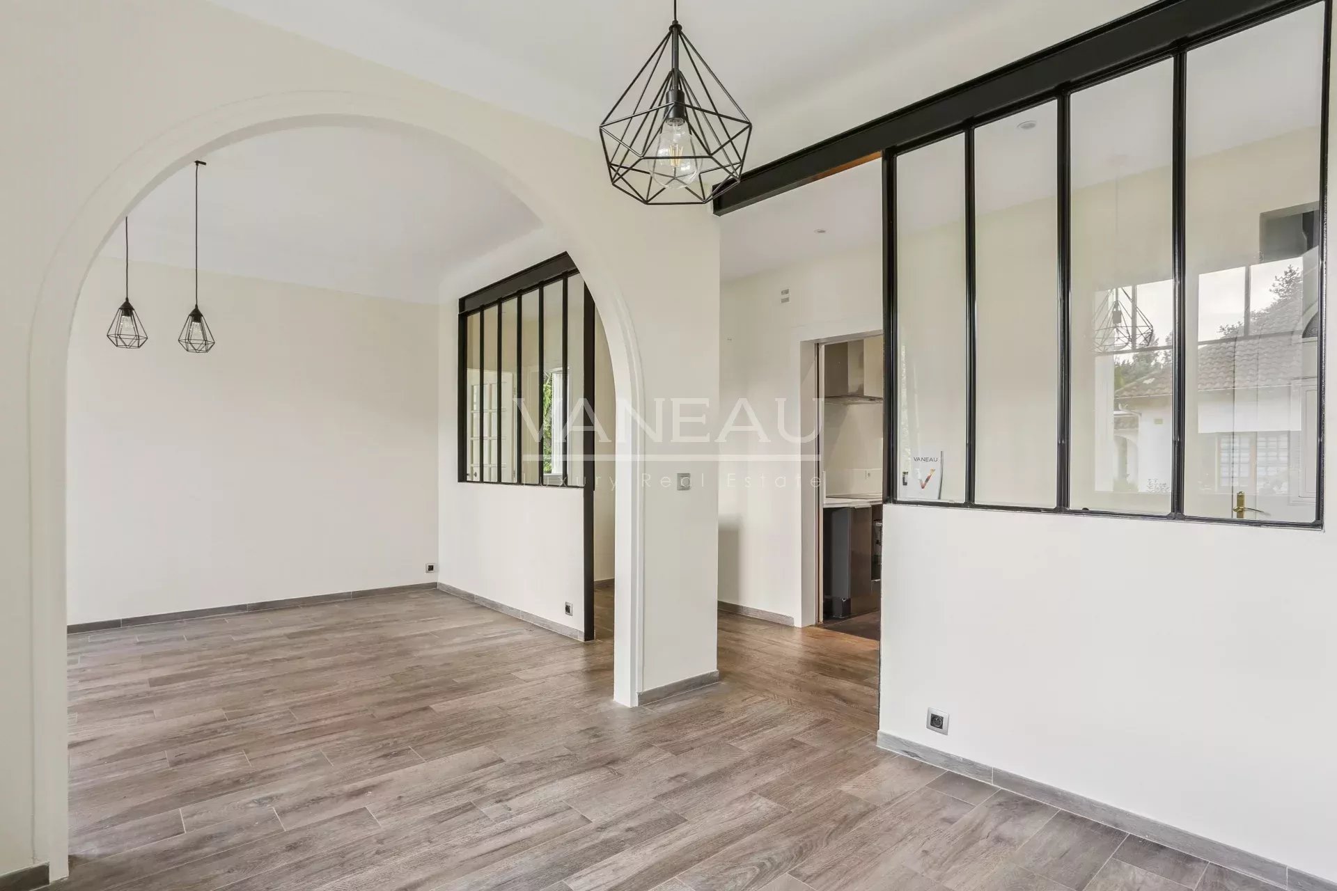 Intérieur d’une maison familiale à Sceaux Intérieur d'une maison rénovée avec un espace ouvert et des fenêtres en verre.