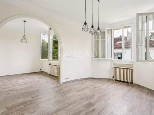 Intérieur d'une maison rénovée avec un séjour lumineux et des fenêtres ouvertes.