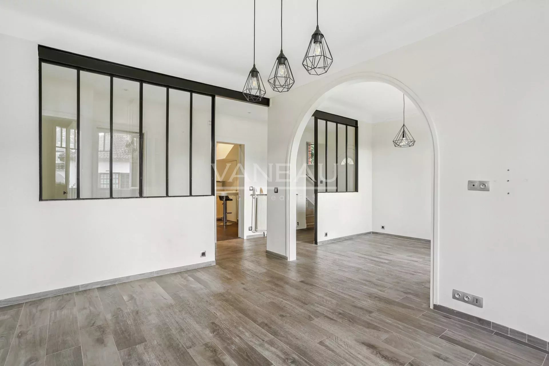 Intérieur d’une maison familiale à Sceaux Intérieur d'une maison rénovée avec un sol en carrelage et des luminaires modernes.