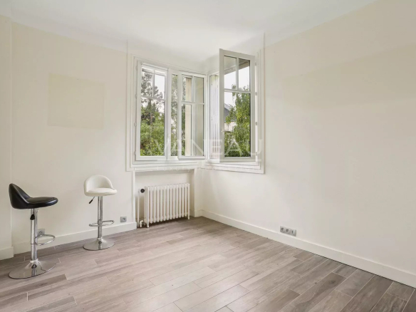 Intérieur d'une maison à Sceaux avec fenêtres et sol en bois.