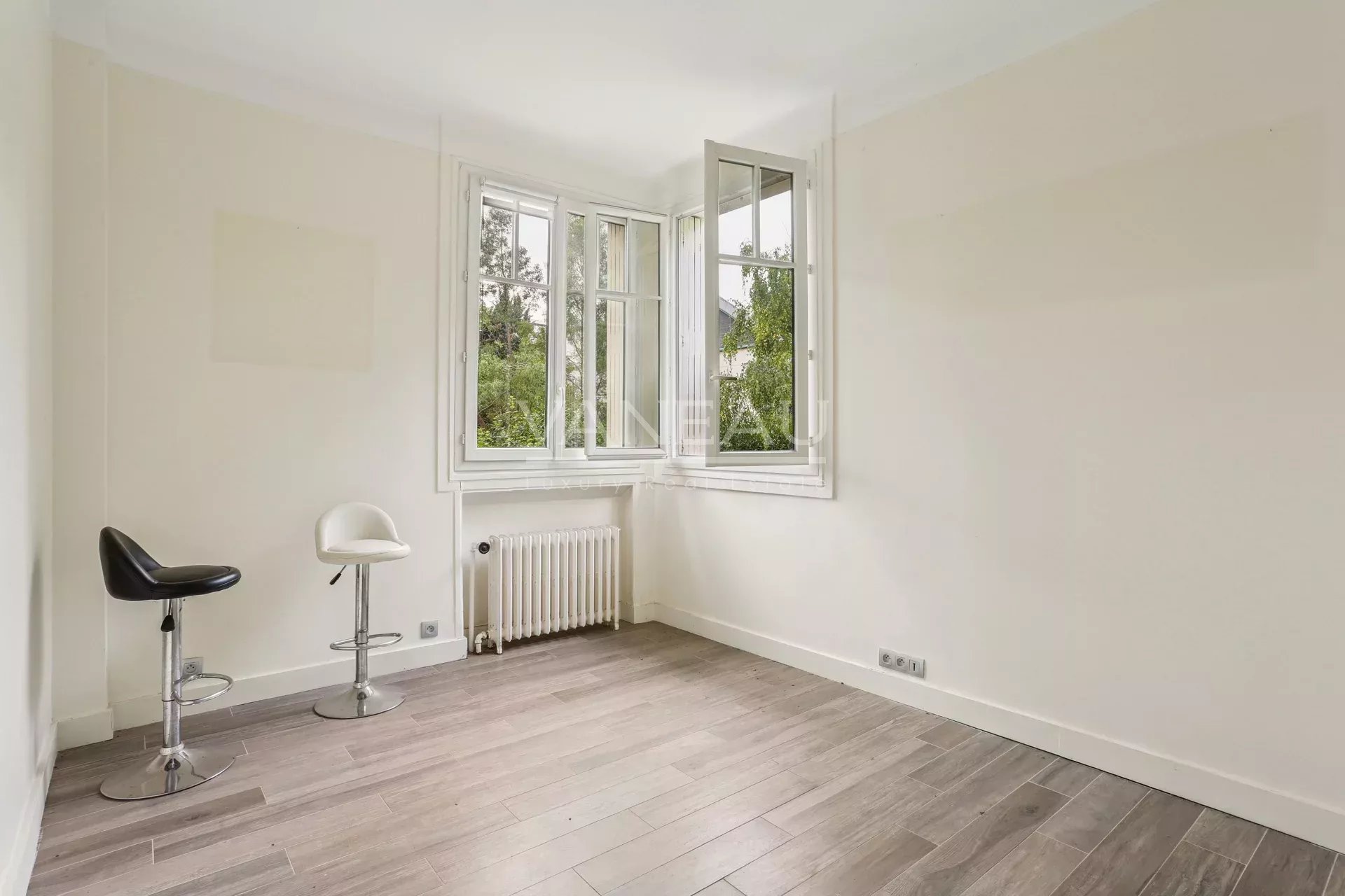 Intérieur d’une maison familiale à Sceaux Intérieur d'une maison à Sceaux avec fenêtres et sol en bois.