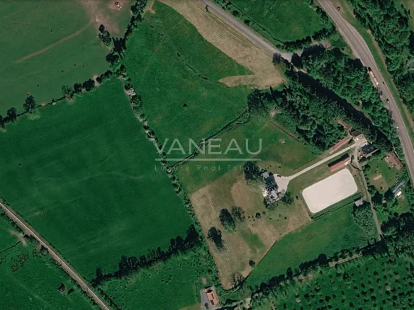 Vue aérienne d'une propriété équestre avec château et prairies à Saint-Julien-sur-Calonne, Pays d'Auge.