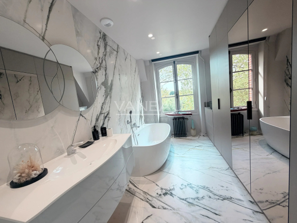 Salle de bain moderne avec baignoire et miroir, éclairage naturel