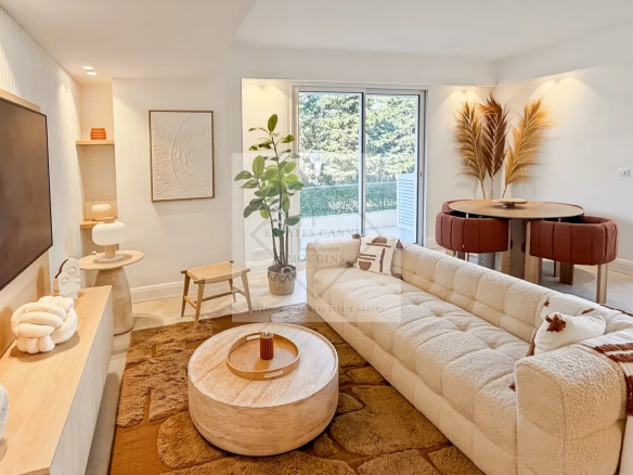Bright, modern living room with a beige tufted sectional, circular coffee table, and sliding glass doors to a balcony.