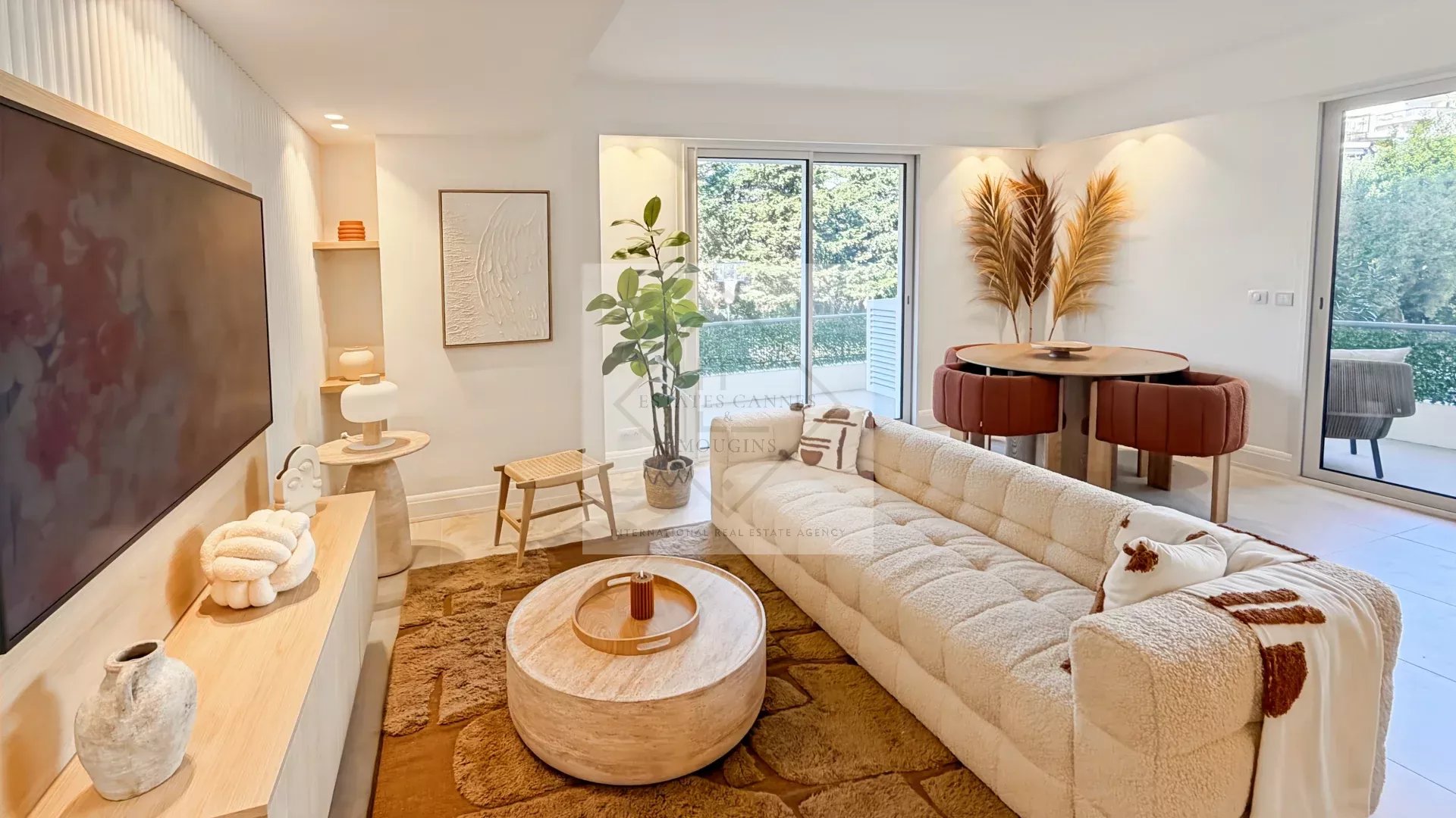 Bright, modern living room with a beige tufted sectional, circular coffee table, and sliding glass doors to a balcony.