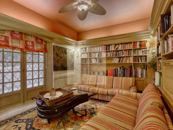 Intérieur d'une villa à Mougins avec salon, bibliothèque et fenêtres en bois.