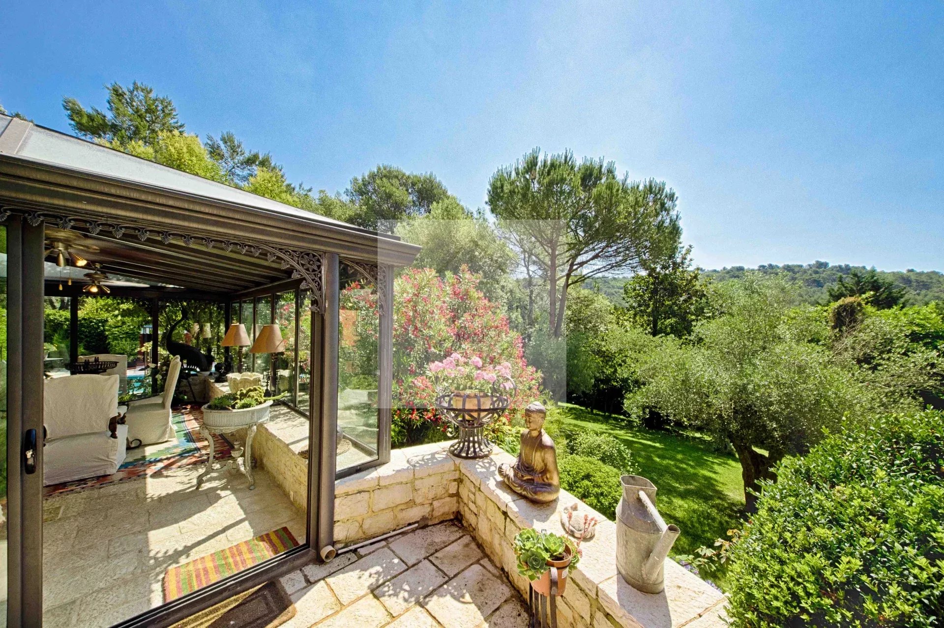 Vue d'une villa avec jardin à Mougins, entourée d'arbres et de fleurs.