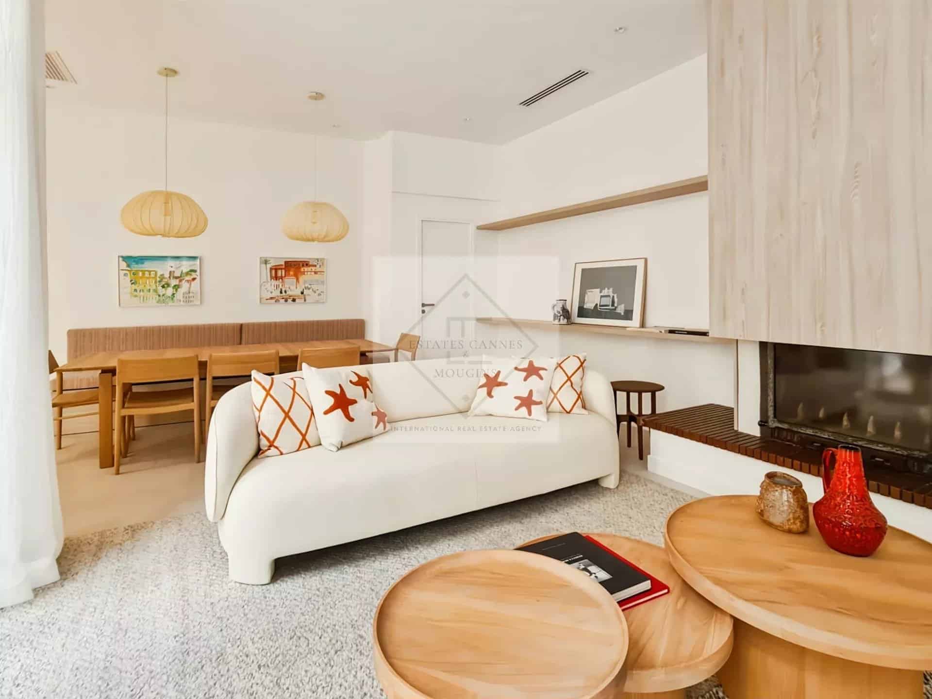 Intérieur d'une maison de ville à Cannes, salon lumineux avec canapé et table basse.