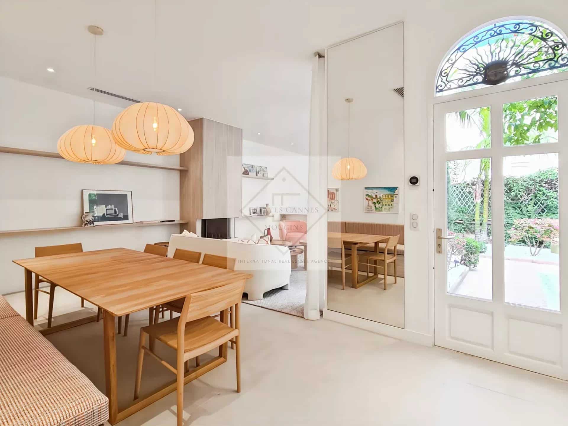 Intérieur d'une maison de ville à Cannes avec salle à manger et accès à un jardin.