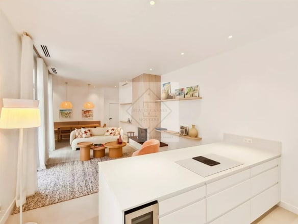 Intérieur moderne d'une maison de ville à Cannes, avec salon lumineux et cuisine ouverte.