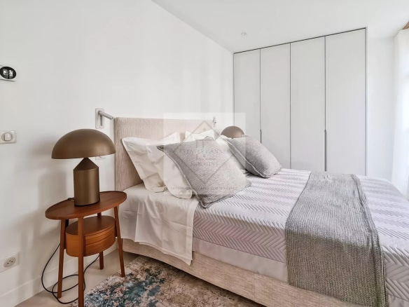 Chambre d'une maison de ville rénovée à Cannes, avec lit, lampe et placard.
