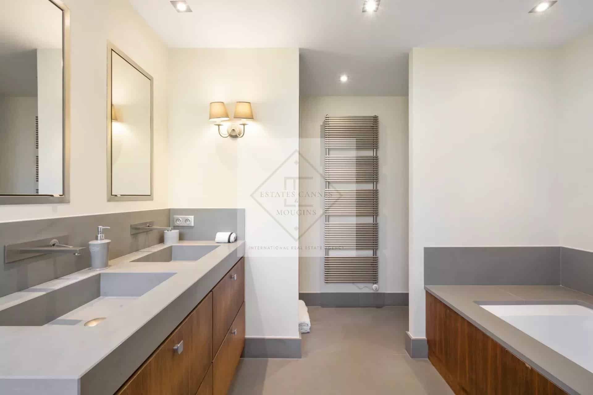 Modern bathroom with sink, bathtub and mirror in a spacious villa.