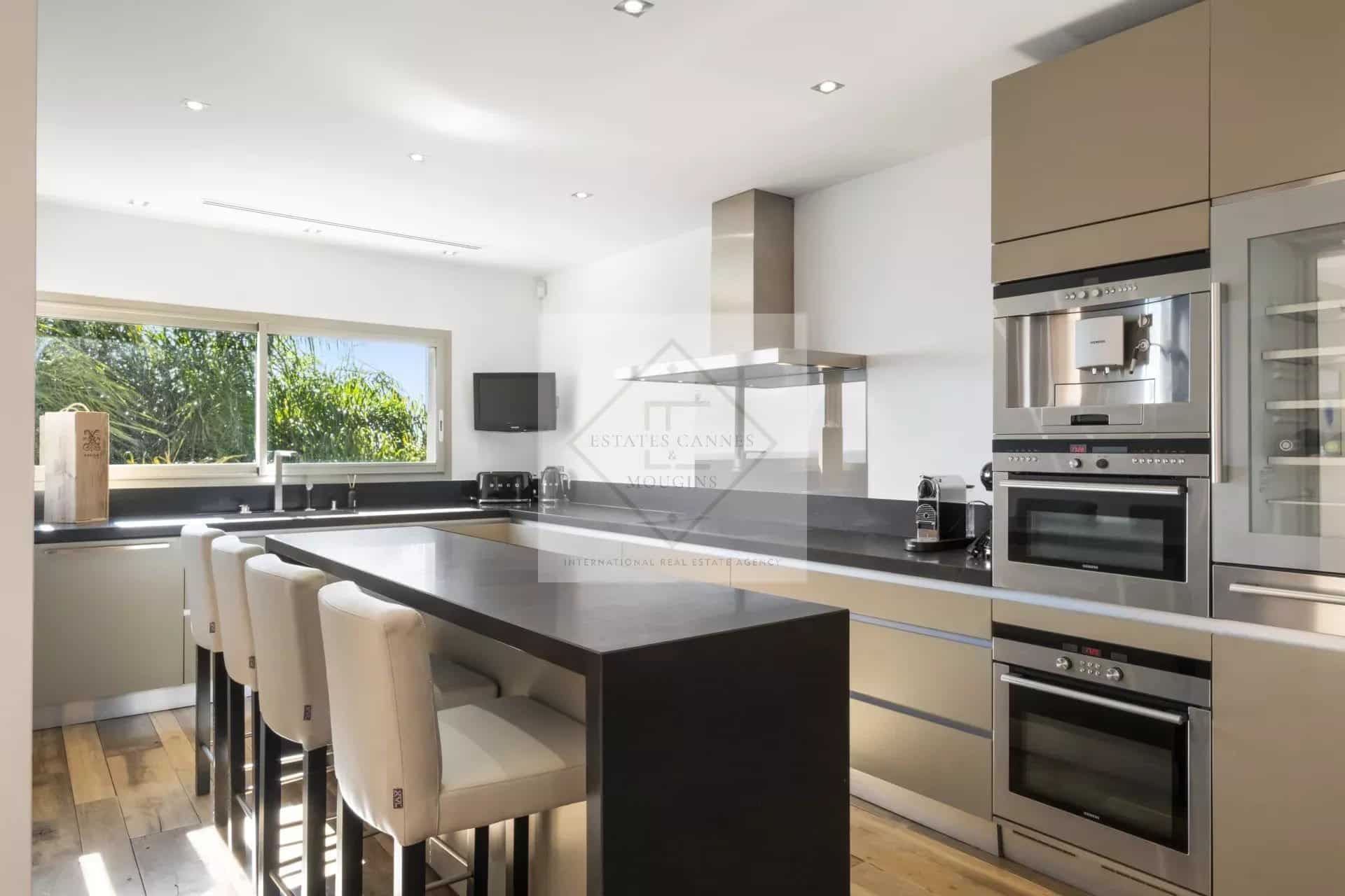 Modern and spacious kitchen in a villa in Cannes with a large central island and modern appliances.