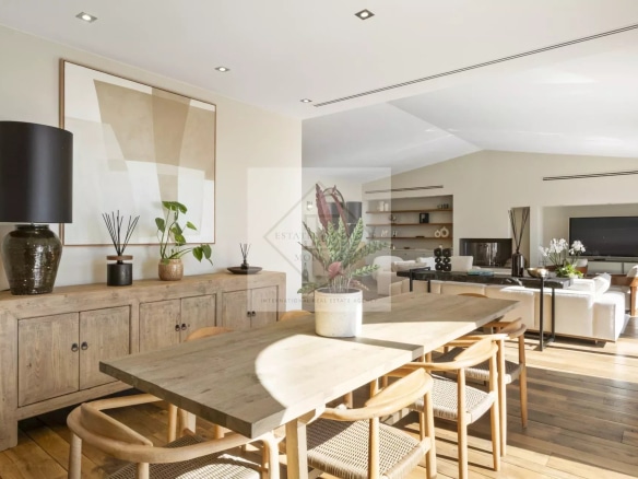 Interior of a spacious villa with a wooden dining room and a modern living room.