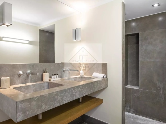 Modern bathroom with stone sink and spacious shower.