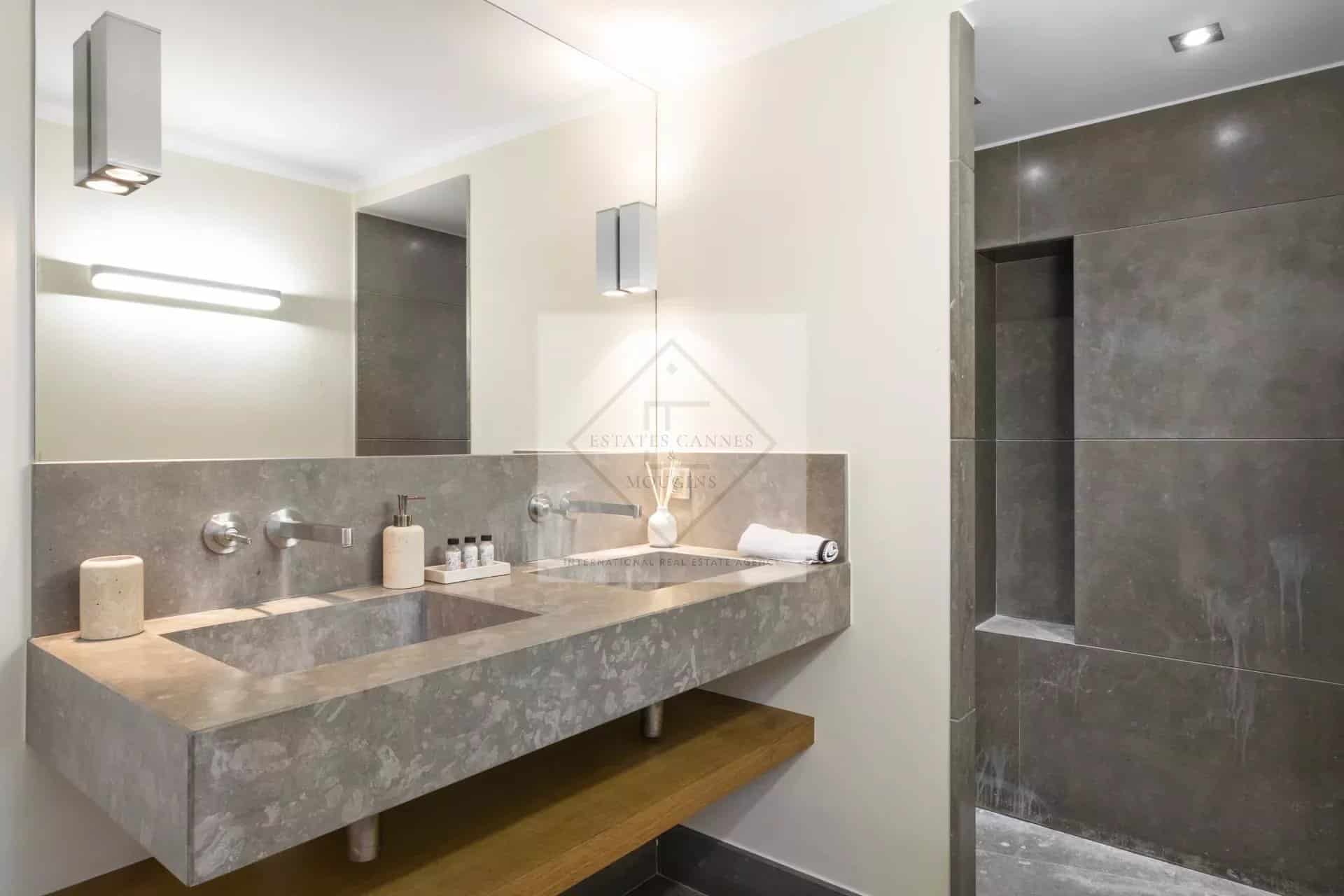 Modern bathroom with stone sink and spacious shower.
