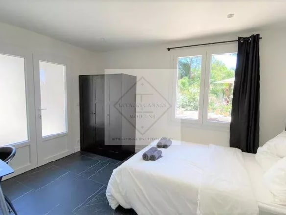 Room in a modern villa in Mougins, with a double bed and windows overlooking the outside.
