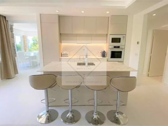 Modern kitchen with central island and bar, natural lighting, in a villa in Mougins.