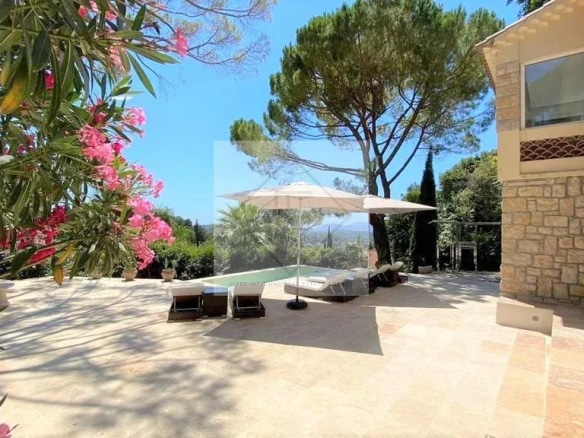 Terrace of a villa with swimming pool, surrounded by flowers and trees in Mougins.