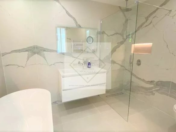 Modern bathroom with walk-in shower and bathtub in a villa in Mougins.
