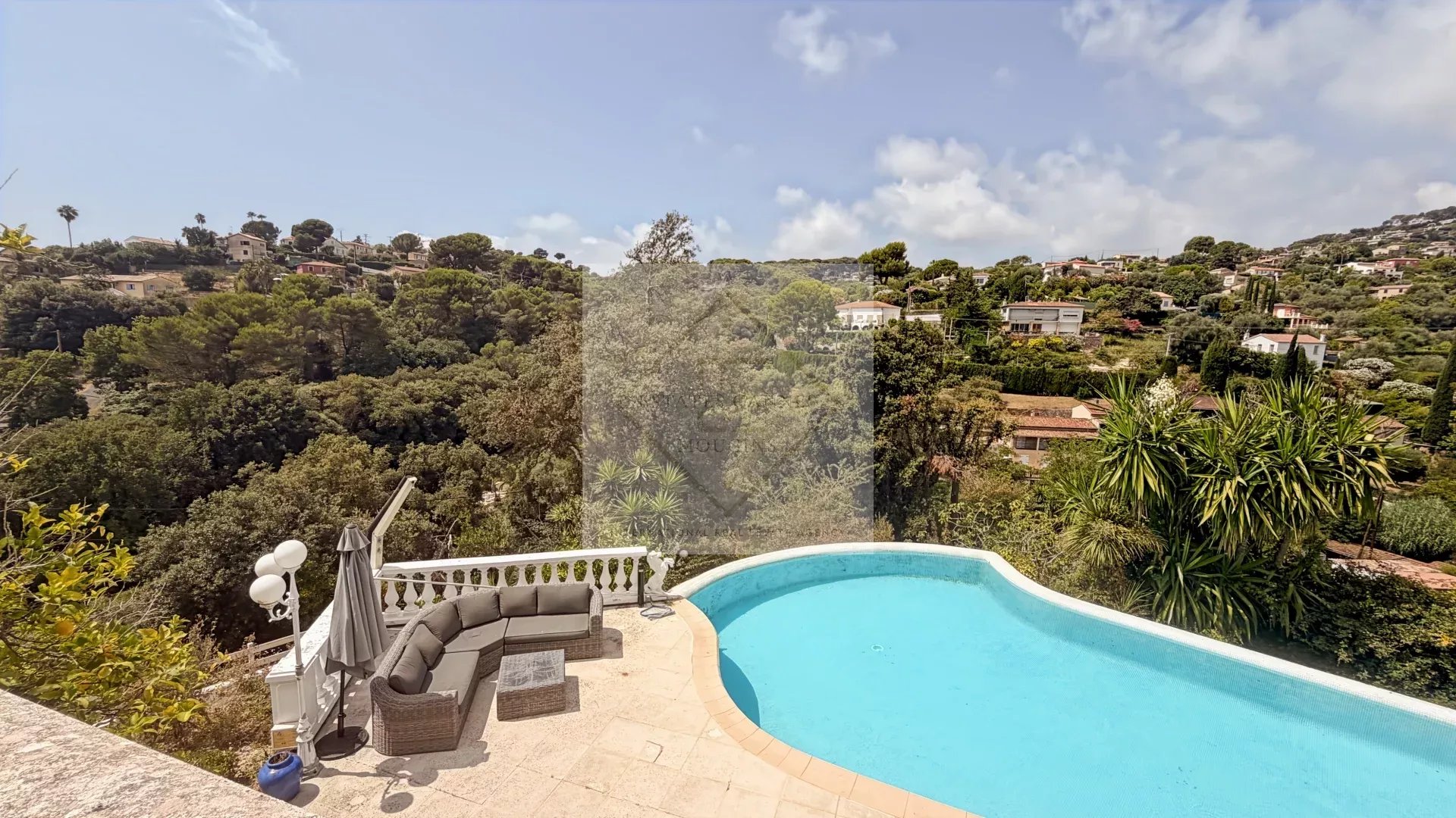 View of a villa with swimming pool and garden, surrounded by greenery in Antibes.
