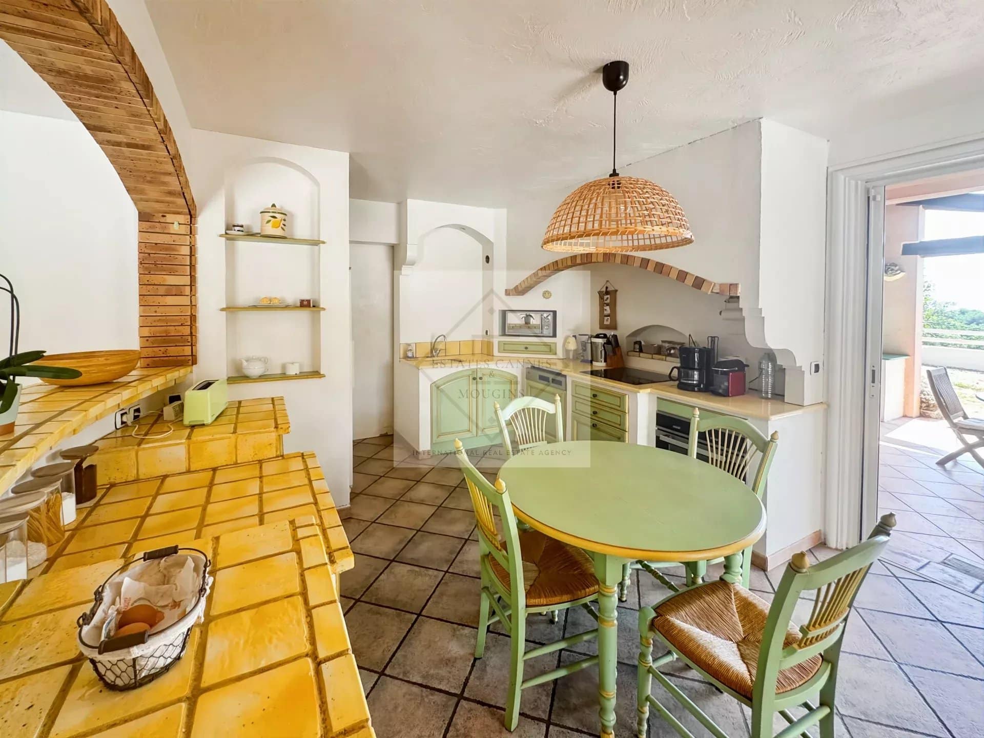 Kitchen of a Provençal villa in Antibes with a round table and wooden chairs.