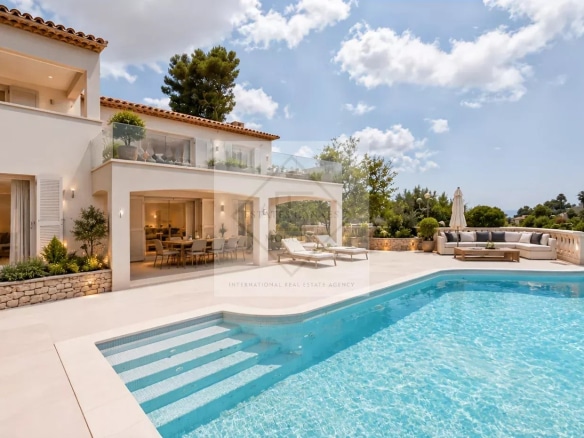Villa with swimming pool and sea view in Antibes, surrounded by greenery.