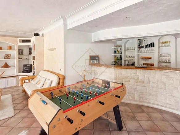 Interior of a villa with a living room, a bar and a foosball table.