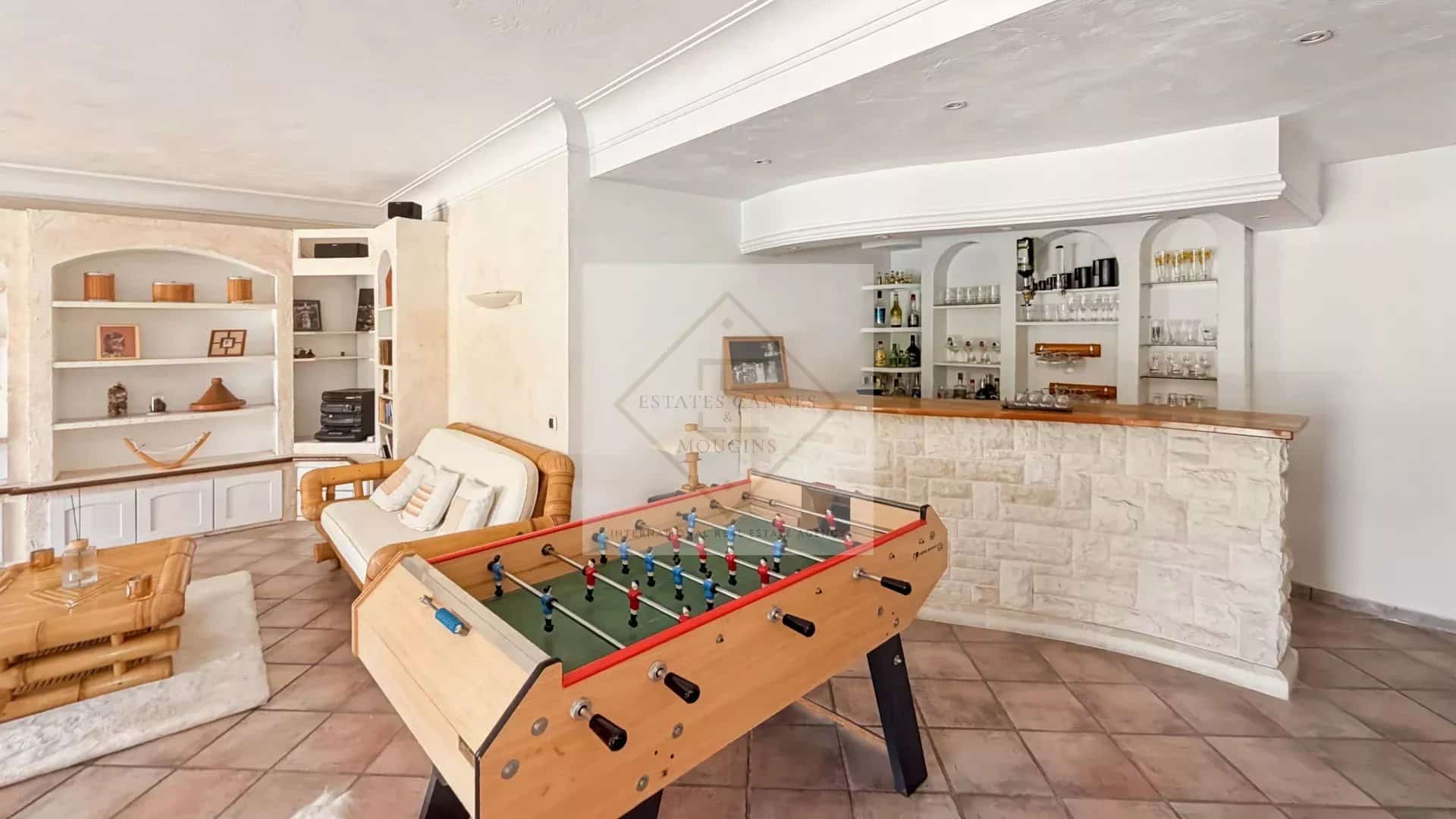 Interior of a villa with a living room, a bar and a foosball table.
